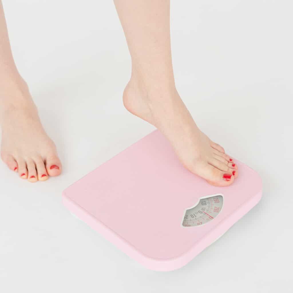 Woman stepping on a scale Woman stepping on a scale