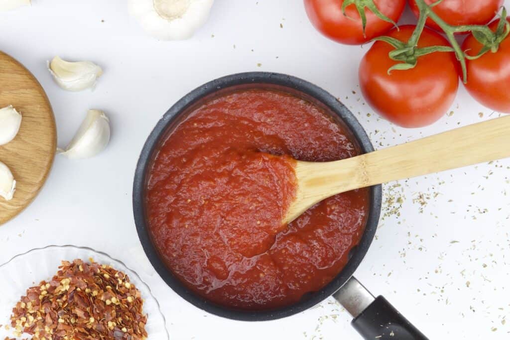 tomato puree in a saucepan to make low sodium pizza sauce. This image shows the right consistency of the pizza sauce