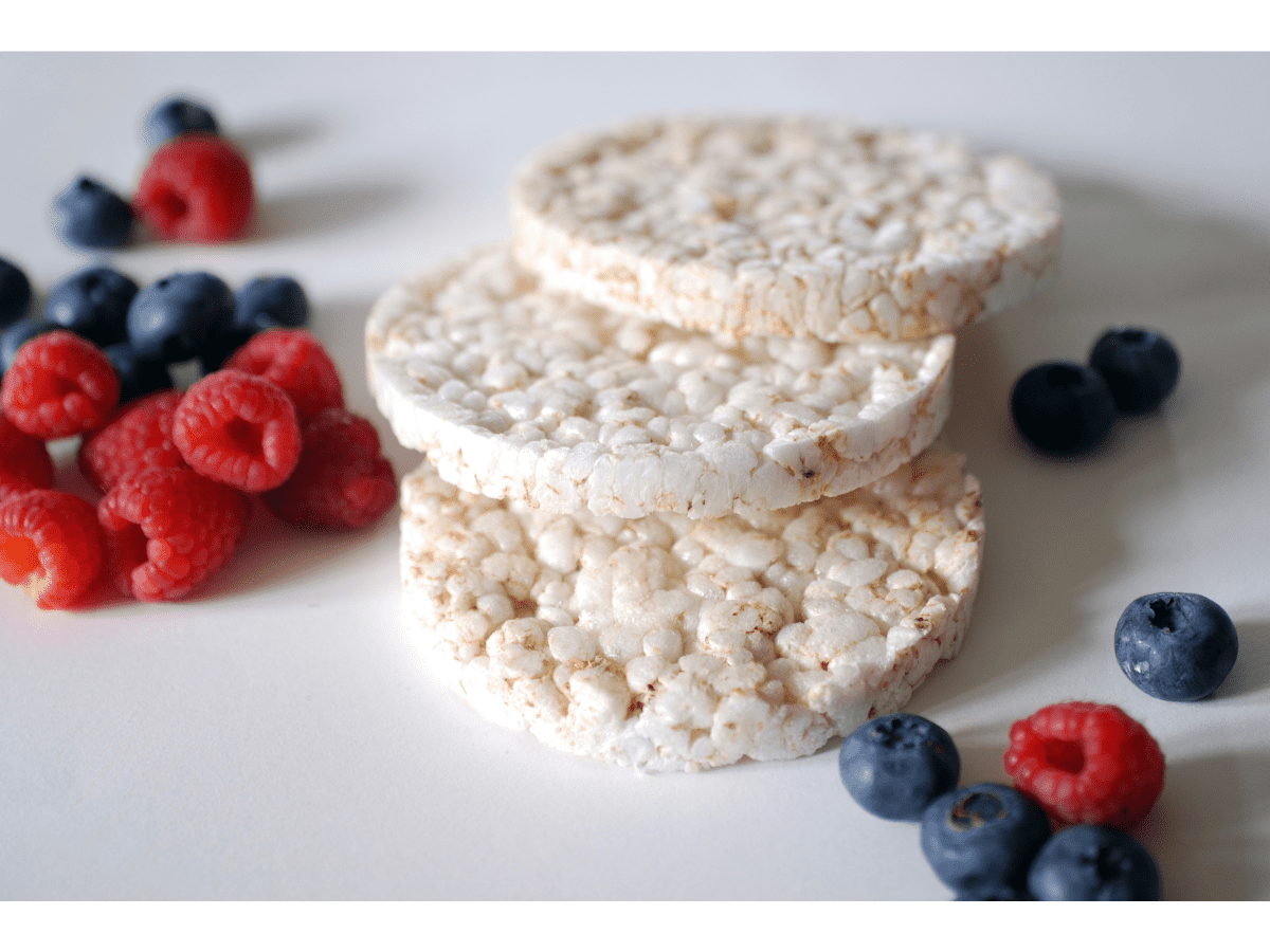 healthy rice cake toppings image of three rice cakes with berries beside them.