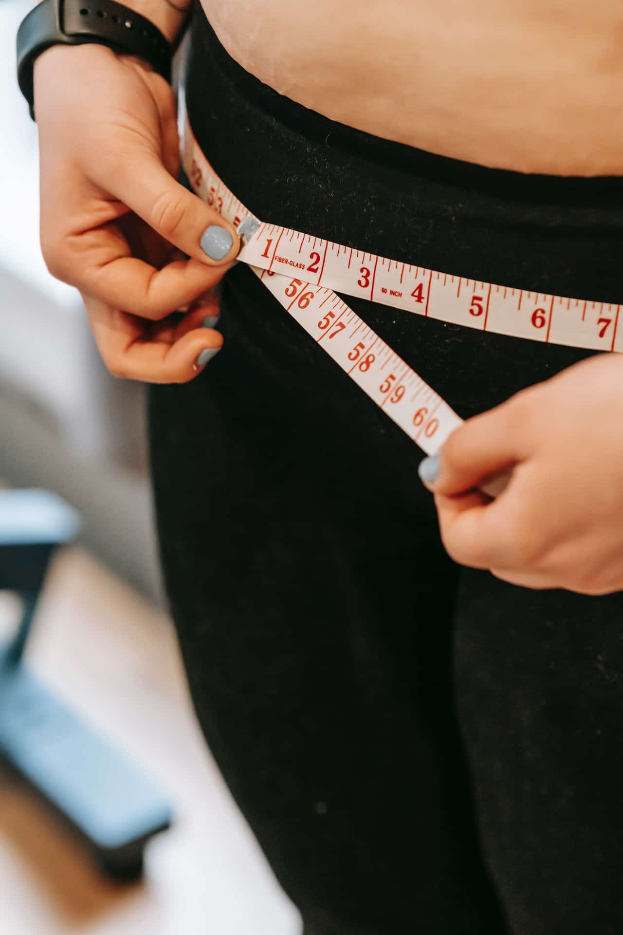 woman checking her measurements for weight loss and figuring out how to overcome weight loss plateau